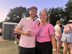 David Fitzpatrick and his partner standing together while holding an inflatable pink flamingo